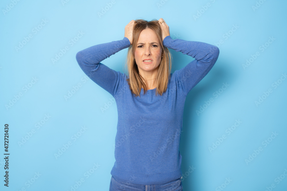Young amazed woman wearing casual sweater standing isolated over blue background. Young amazed woman wearing casual sweater standing isolated over blue background.