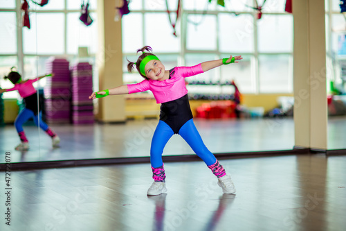 a small, beautiful girl,doing sports in the gym,in bright, colored sportswear