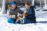 Young family, couple in love on a winter walk with a beagle puppy.