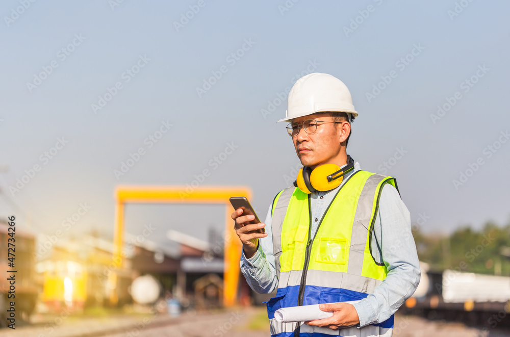 Engineer man in waistcoats and hardhats in a railway depot, Engineer under inspection and checking construction process railway locomotive repair plant Engineer man in waistcoats and hardhats in a railway depot, Engineer under inspection and checking construction process railway locomotive repair plant