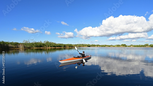 Woman kayaking on Nine Mile Pond in Everglades National Park, Florida on calm sunny autumn afternoon.