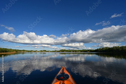 Kayaking on Nine Mile Pond in Everglades National Park, Florida on sunny autumn afternoon under cloudscape reflected in calm water.
