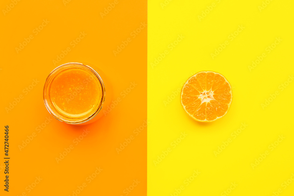 Fototapeta Jar of tasty tangerine jam on color background