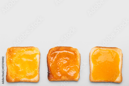 Tasty toasts with tangerine jam on white background