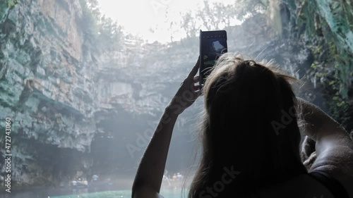 Tourist Taking Photos At The Scenic Melissani Cave on the island of Kefalonia, Greece - handheld shot photo
