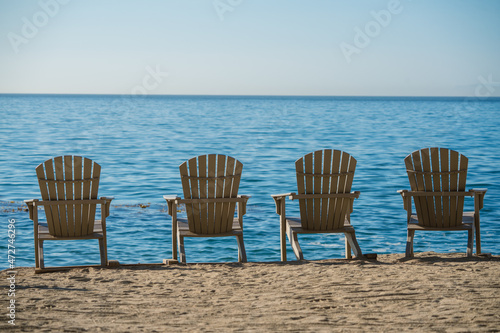 Obraz na plátne Adirondack chairs  on the sea coast invoke a vacation or retirement