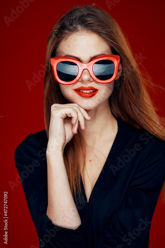 pretty woman wearing sunglasses fashion posing hairstyle red background