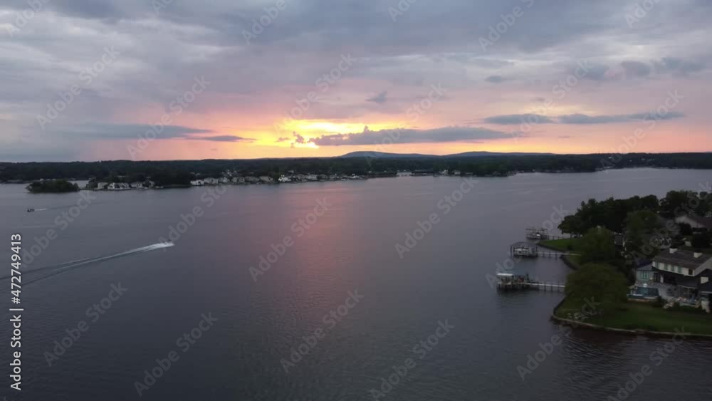 Drone shot of sunset on a lake with a couple boats skimming by. Drone shot of sunset on a lake with a couple boats skimming by.
