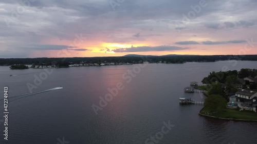 Drone shot of sunset on a lake with a couple boats skimming by. photo