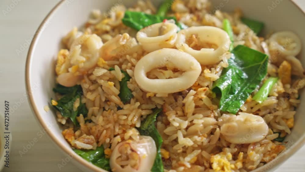 Fried rice with squid or octopus in bowl - stir-fried rice with squid, egg and kale Fried rice with squid or octopus in bowl - stir-fried rice with squid, egg and kale