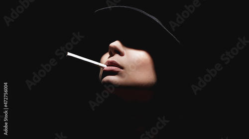 Beautiful woman in a hat and with a cigarette