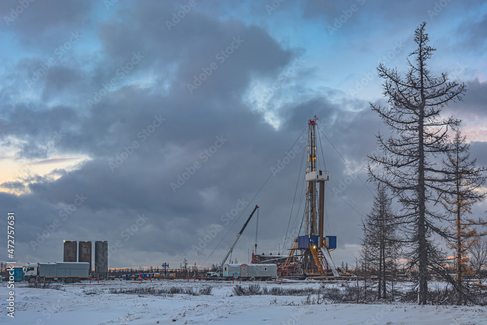 A harmonious combination of nature and the technogenic landscape of an oil and gas field with a drilling rig and special equipment in the polar tundra