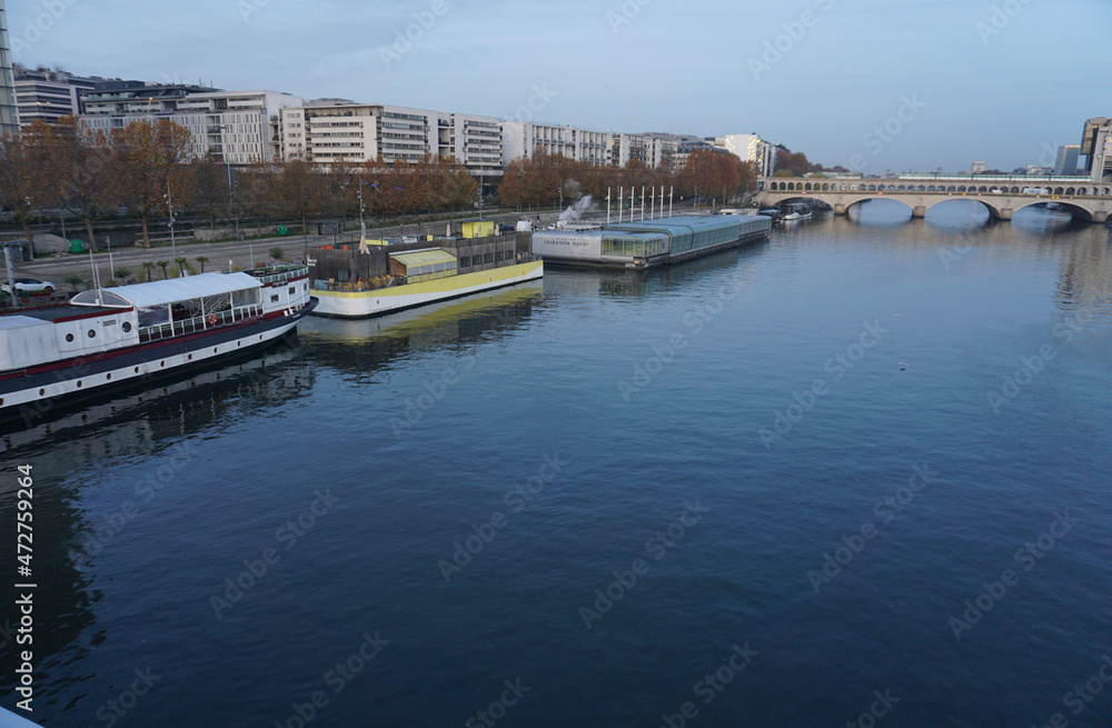 downtown paris france from seine river with old wooden barges early morning and stone bridge with subway train