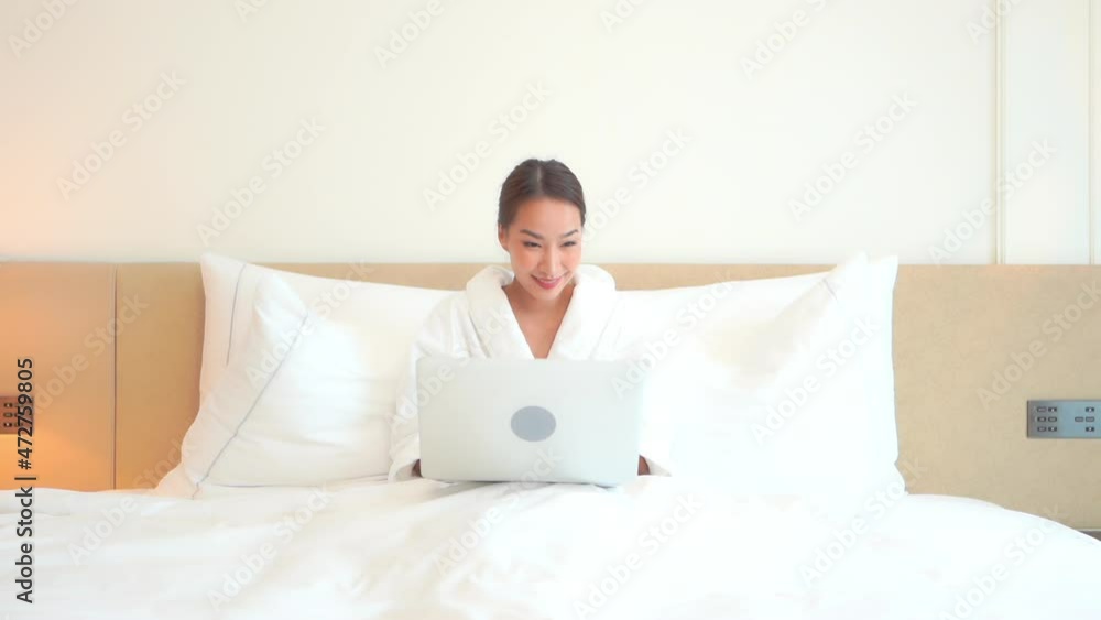 Working From Home, Pretty Asian Woman in Bed Wearing Bathrobe Typing on a Laptop Computer on Bright Morning, Full Frame Working From Home, Pretty Asian Woman in Bed Wearing Bathrobe Typing on a Laptop Computer on Bright Morning, Full Frame