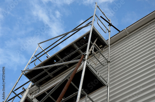 construction of an industrial hall. corrugated sheet metal facade work. The scaffolding is foldable and supports fo high heights like a chimney. fixed against the wind by support rods