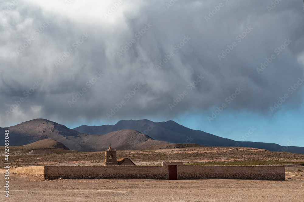 Bolivia, Altiplano, Potosi, San Juan. View of the cemetery surrounded by a mud brick wall with a chapel inside.