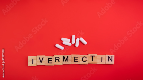 Ivermectin on colored red paper texture background. Ivermectin antiparasitic medication. Off label approved medicine drugs use. Covid-19 therapy. Pharmacy concept. Copy space. Mock up design template