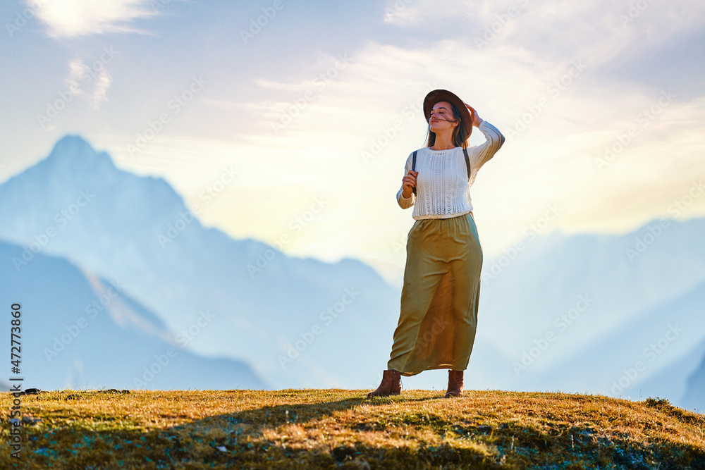 Serene peaceful young girl traveler backpacker wearing hat standing alone and enjoying freedom, silence and calm traveling Serene peaceful young girl traveler backpacker wearing hat standing alone and enjoying freedom, silence and calm traveling
