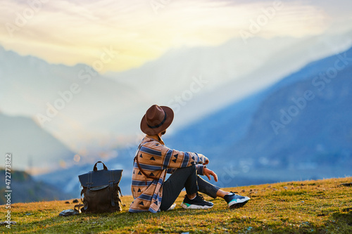Canvas Print Hipster man traveler wanderer wearing hat sitting alone and enjoying freedom and