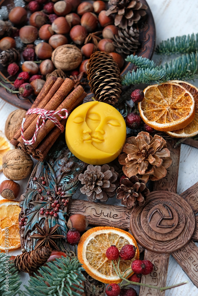 Wiccan altar for Yule sabbath, pagan holiday. Sun and moon symbol, wheel of the year, cinnamon, nuts, cones, dry orange slices. Witchcraft Ritual for Yule, Magical Winter Solstice