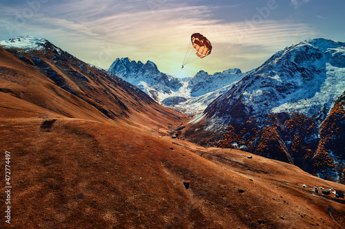 Parachutist flies over a picturesque scenic mountain valley. Enjoying of flying in the air with a feeling of weightlessness and freedom