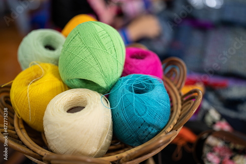 Balls of yarn for knitting. Balls of yarn for knitting in a wicker basket. A knitting yarn, knitted clothes, create coziness. Colorful multi-colored yarn for knitting.