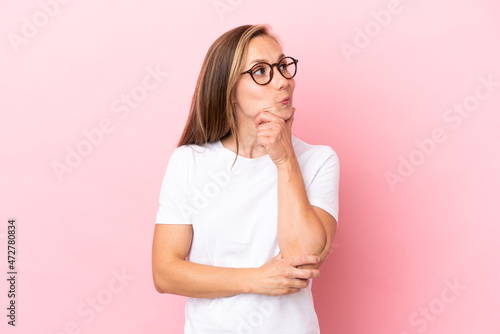 Young English woman isolated on pink background thinking an idea while looking up