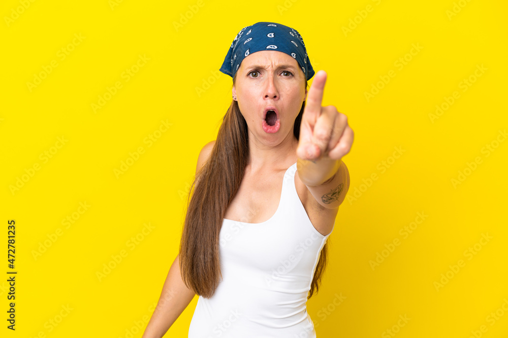 Young English woman isolated on yellow background frustrated and pointing to the front Young English woman isolated on yellow background frustrated and pointing to the front