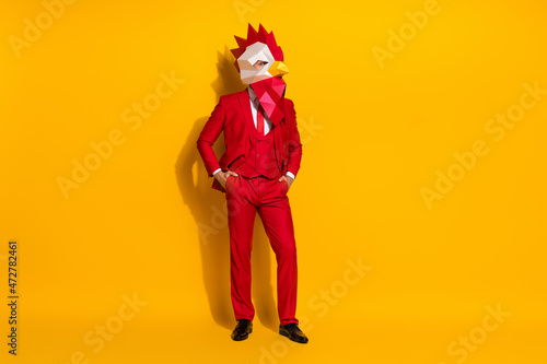 Photo of successful manager guy hands pockets wear rooster polygonal mask red tux isolated yellow color background