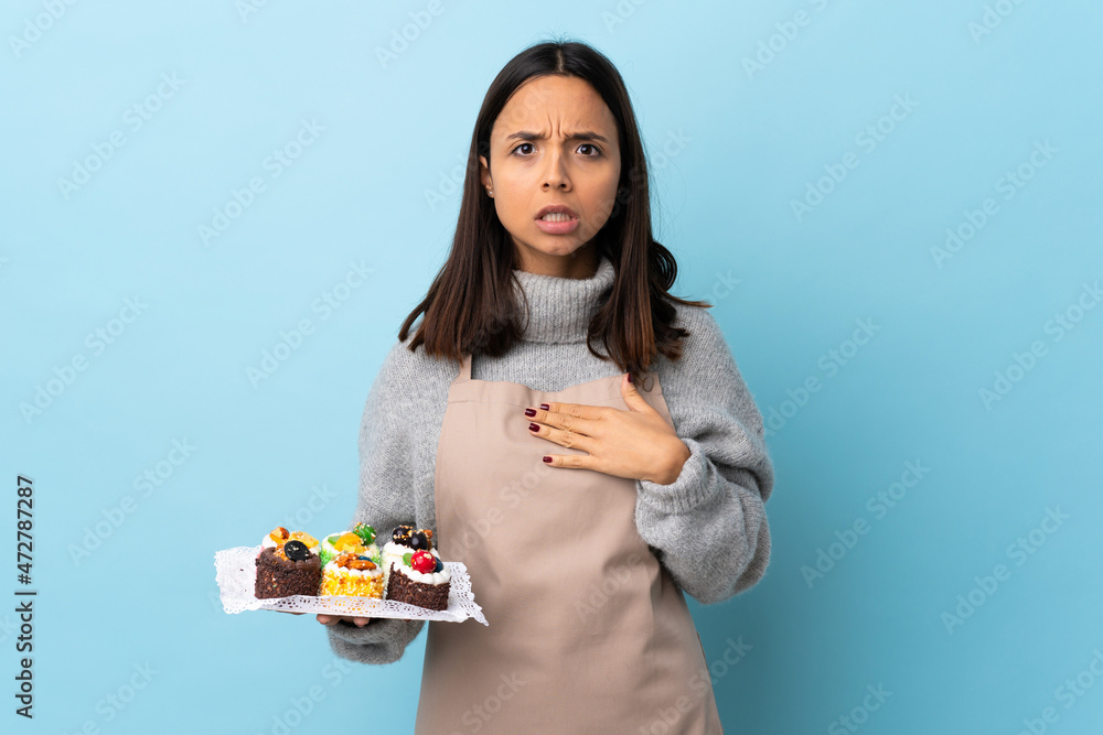 Pastry chef holding a big cake over isolated blue background pointing to oneself. Pastry chef holding a big cake over isolated blue background pointing to oneself.