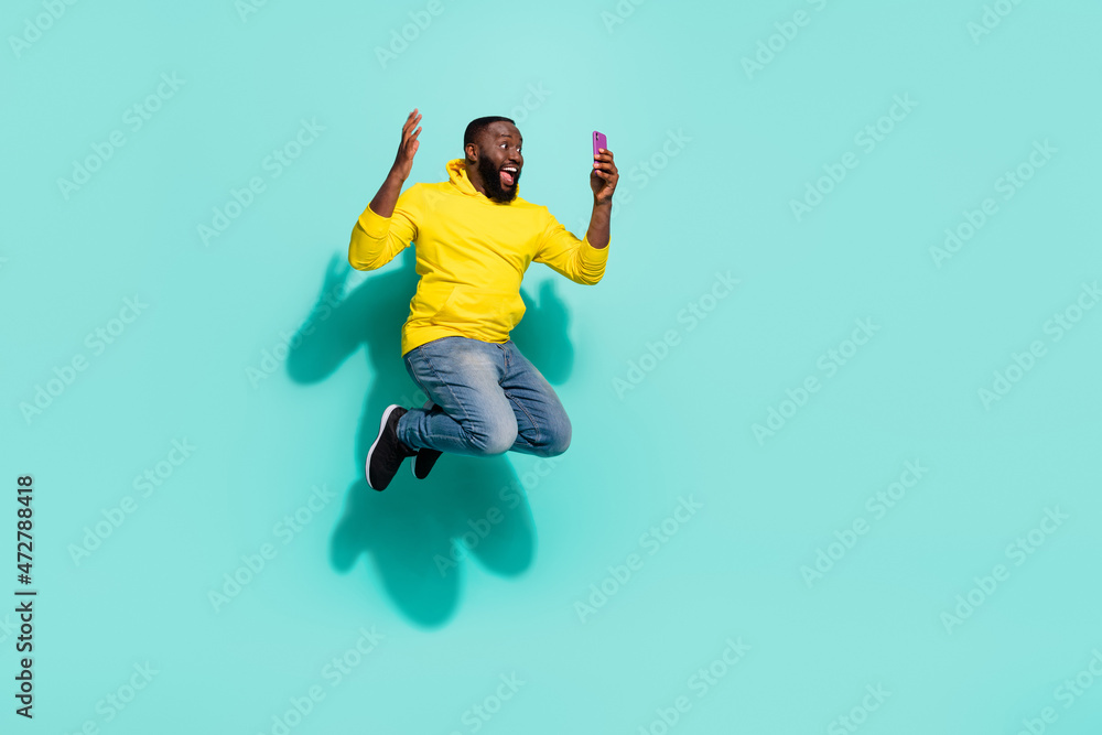 Full length photo of excited guy jump find bargain website chat isolated over turquoise color background