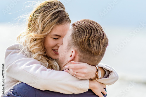 Young couple in love on the beach in spring or autumn,blur water,sea,ocean background.Love concept.close-up.