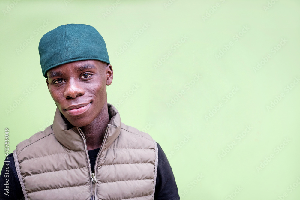 Trendy African man looking at camera against green background Trendy African man looking at camera against green background