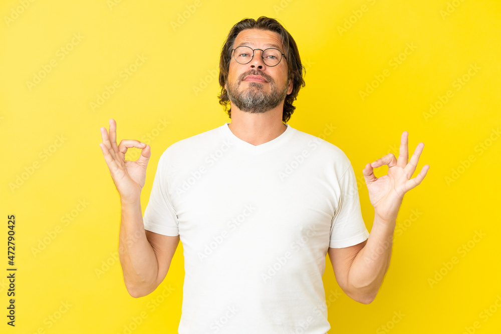 Senior dutch man isolated on yellow background in zen pose Senior dutch man isolated on yellow background in zen pose
