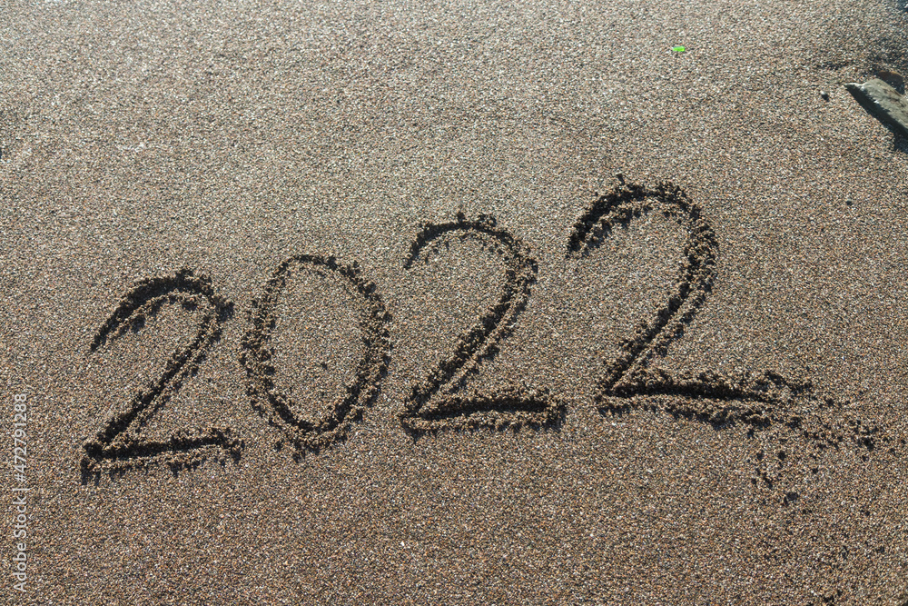 Fototapeta premium 2022 written in the sand of a beach, new year travel greeting card