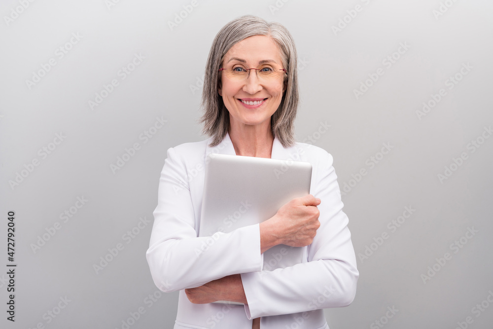 Photo of optimistic white hairdo elder working lady hold laptop wear spectacles jacket isolated on grey color background Photo of optimistic white hairdo elder working lady hold laptop wear spectacles jacket isolated on grey color background