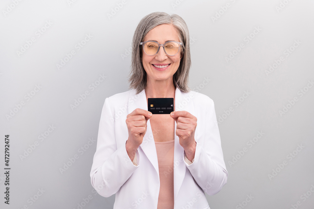 Photo of optimistic white hairdo elder manager lady hold card wear spectacles jacket isolated on grey color background Photo of optimistic white hairdo elder manager lady hold card wear spectacles jacket isolated on grey color background
