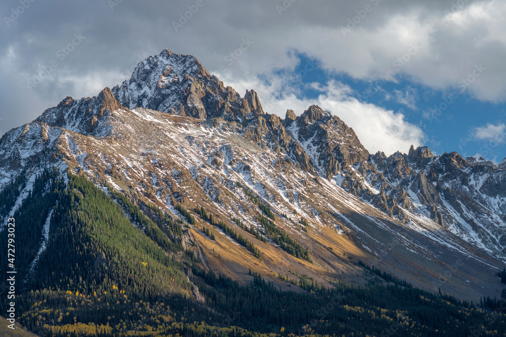 USA, Colorado. San Juan Mountains, Uncompahgre National Forest, evening light warms Mt. Sneffels and the Sneffels Range above autumn aspen and evergreen trees.