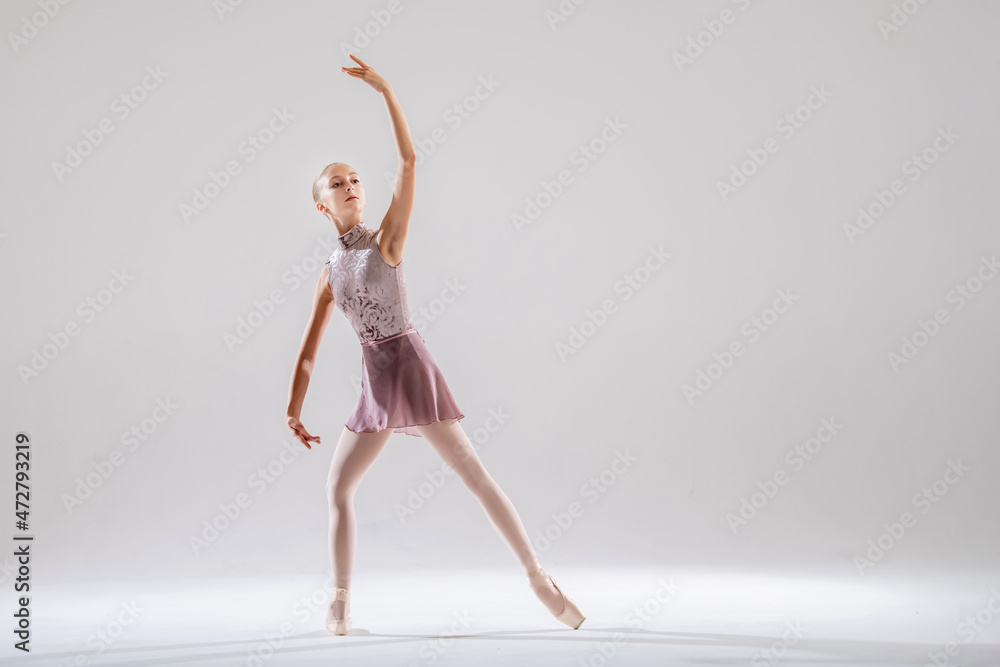 Beautiful young girl ballerina in pointe shoes and pink swimsuit on light background. Beautiful young girl ballerina in pointe shoes and pink swimsuit on light background.