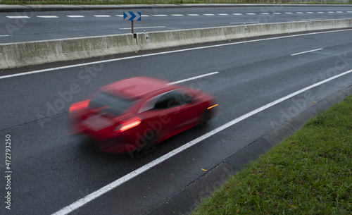 Red car driving fast on the curve of road © poliki