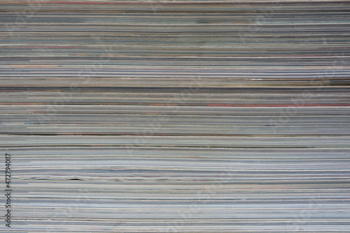 Abstract background is a stack of sheets from magazines and newspapers.
