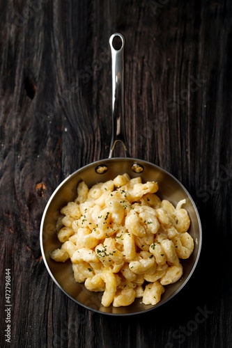Creamy Macaroni and Cheese on a Skillet Oan with Parmesan and Herbs, Isolated on Wooden Table, Top View photo