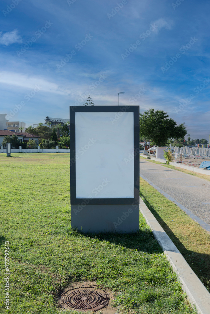 Blank billboard by the sea, on the grass and under cloudy sky. Ideal photo for holiday brochure. Selective Focus Blank billboard by the sea, on the grass and under cloudy sky. Ideal photo for holiday brochure. Selective Focus