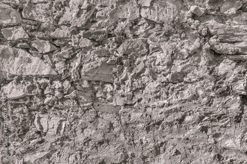 Old grungy retro dirty faded brick wall of ancient city. Uneven pitted peeled surface brickwork of cellar worn. Ruined shabby stiff blocks.Hard solid messy ragged holes brickwall of 3D grunge design