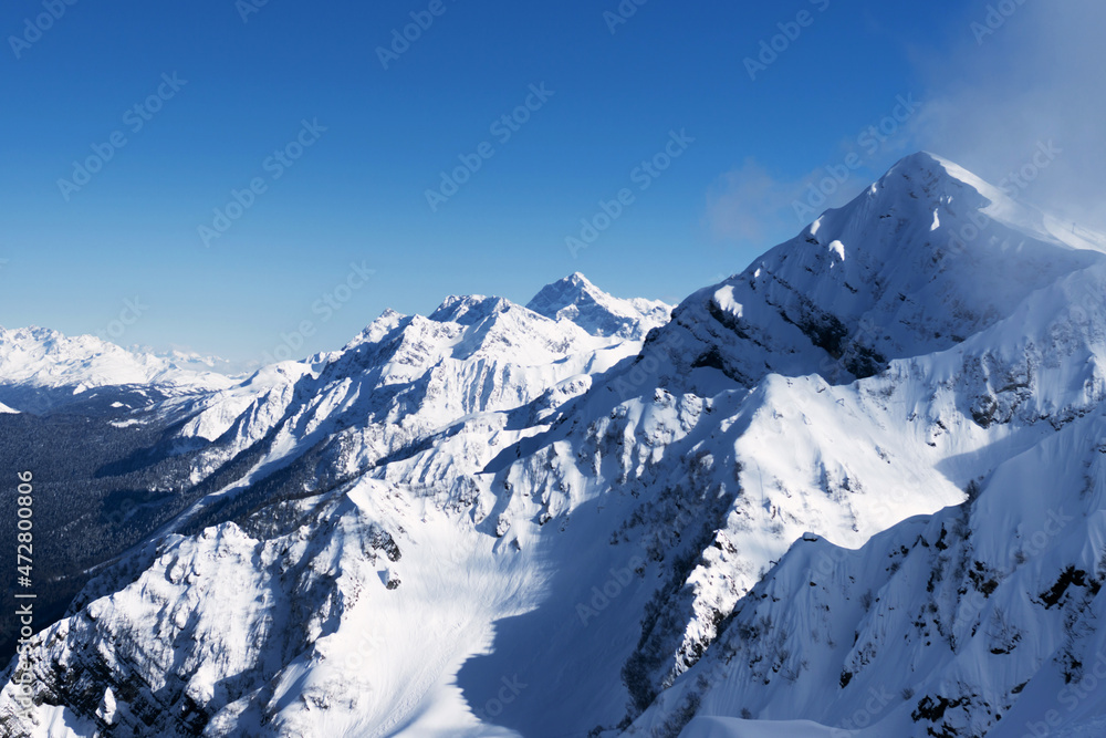 Snow-capped mountain peaks. Natural background. Ski resort Caucasus Mountains nature and sports.