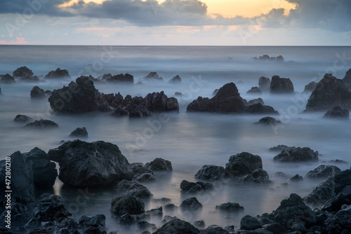 USA, Hawaii, Big Island of Hawaii. Laupahoehoe Point Beach Park, Dawn sky over waves and rough volcanic rock.
