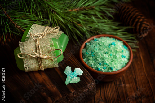 Spruce bath salt on a wooden background. Spruce branches in the background