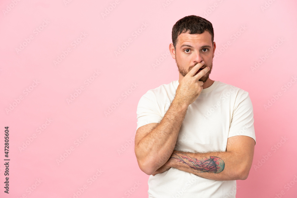 Young Brazilian man isolated on pink background surprised and shocked while looking right Young Brazilian man isolated on pink background surprised and shocked while looking right