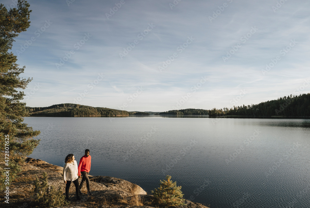 Couple walking at lakeshore during vacation