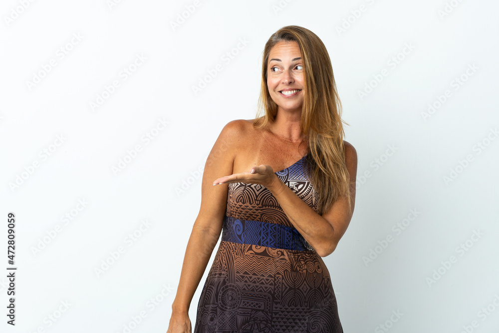 Middle age brazilian woman over isolated background presenting an idea while looking smiling towards Middle age brazilian woman over isolated background presenting an idea while looking smiling towards